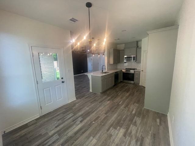 2303 White Wing Dr, Navasota, TX 77868 - kitchen featuring stainless steel appliances, a chandelier, dark wood-style flooring, tasteful backsplash, and light countertops