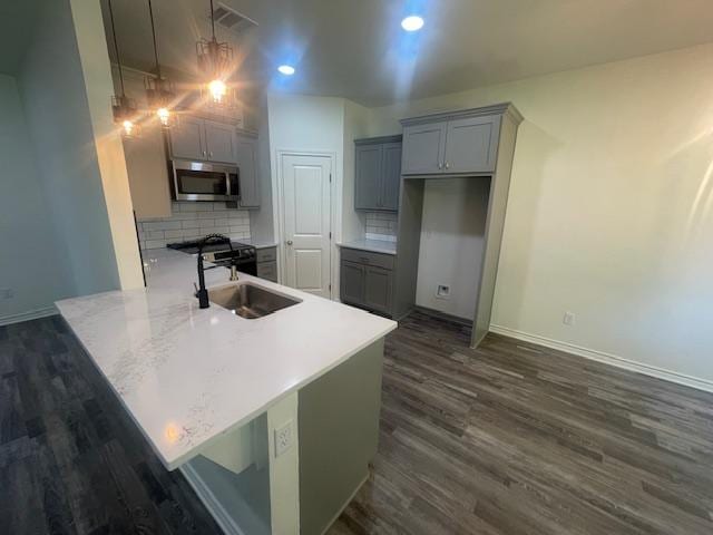 2303 White Wing Dr, Navasota, TX 77868 - kitchen with stainless steel microwave, gray cabinetry, dark wood-style flooring, a sink, and recessed lighting