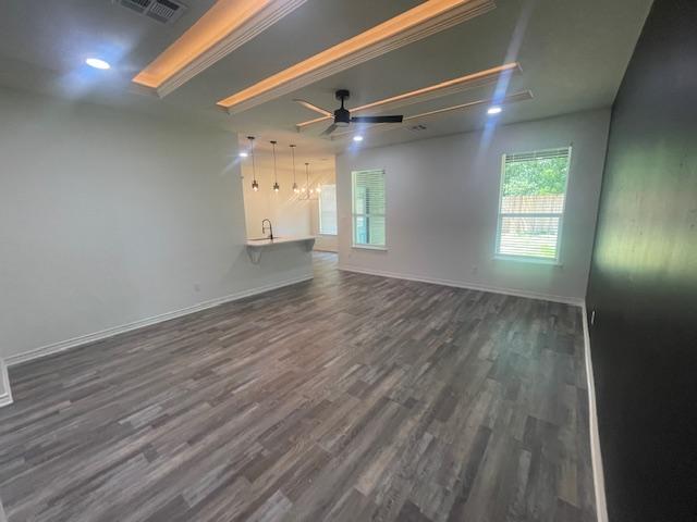 2303 White Wing Dr, Navasota, TX 77868 - unfurnished living room with dark wood finished floors, a ceiling fan, and baseboards