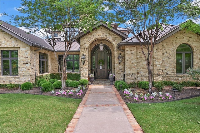 view of exterior entry with a lawn