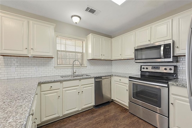 kitchen featuring light stone countertops, sink, dark hardwood / wood-style floors, and appliances with stainless steel finishes