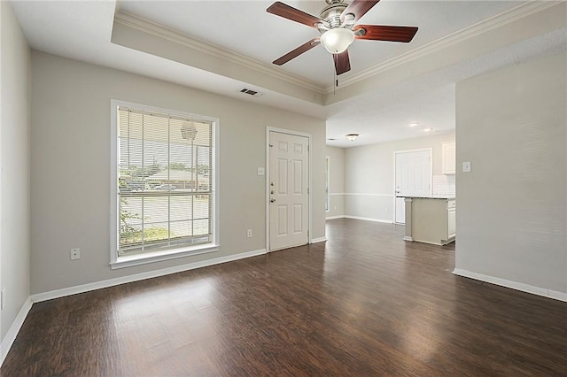 unfurnished room featuring dark hardwood / wood-style flooring, a tray ceiling, and ornamental molding