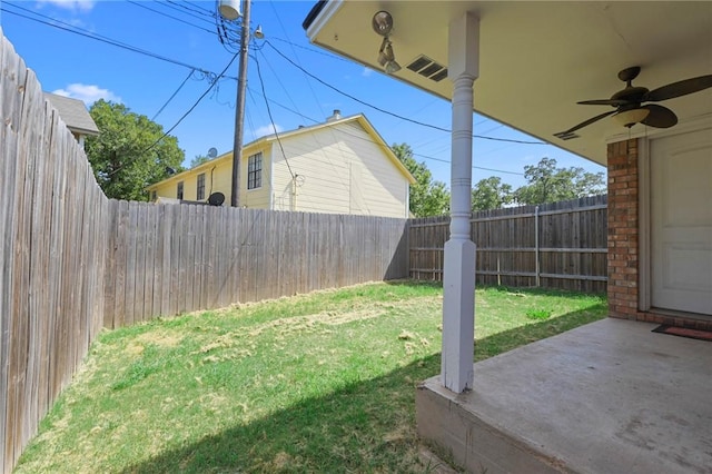 view of yard with ceiling fan and a patio