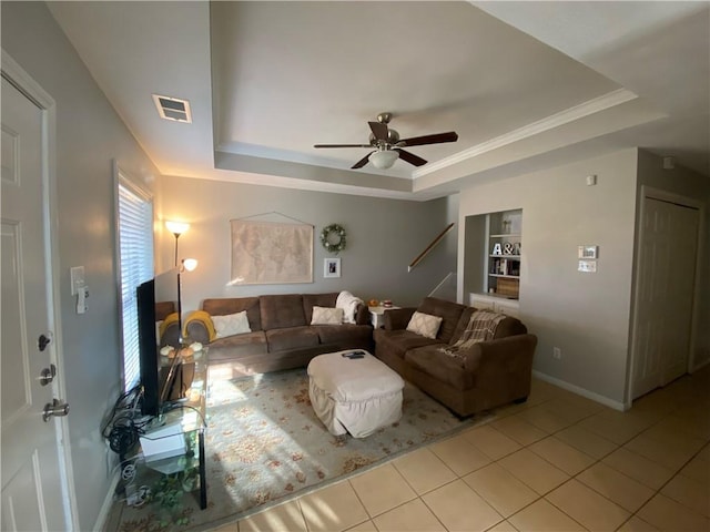 living room with light tile patterned floors, a raised ceiling, and ceiling fan