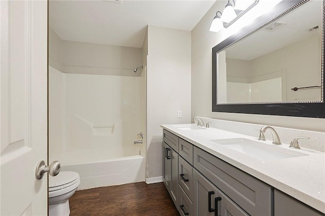 full bathroom with hardwood / wood-style floors, vanity, toilet, and shower / bath combination