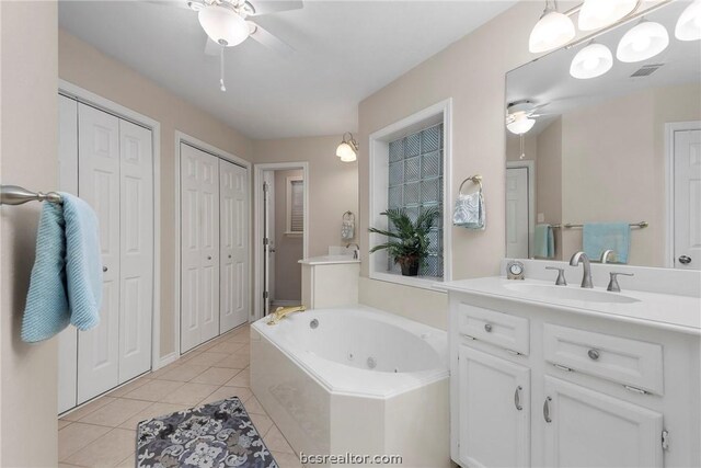 bathroom featuring tile patterned flooring, vanity, tiled bath, and ceiling fan