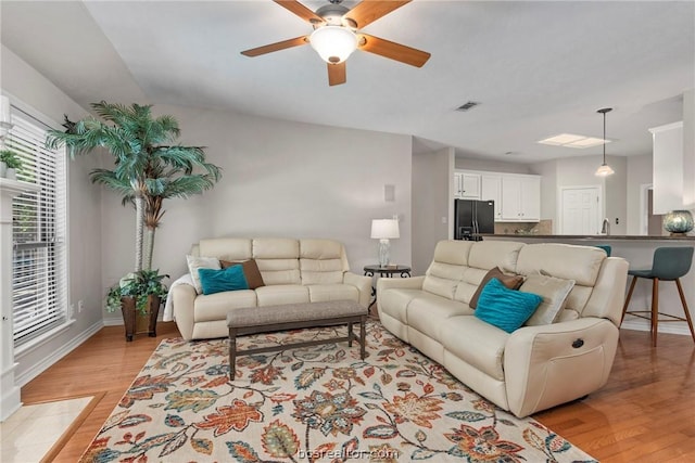 living room with light hardwood / wood-style flooring and ceiling fan