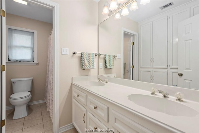 bathroom with tile patterned flooring, vanity, and toilet