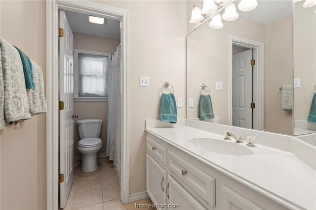 bathroom featuring toilet, vanity, tile patterned floors, and a notable chandelier