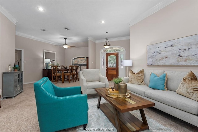 carpeted living room featuring ceiling fan and crown molding