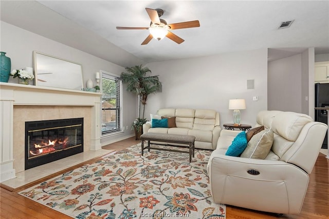 living room with ceiling fan, light hardwood / wood-style floors, and a fireplace