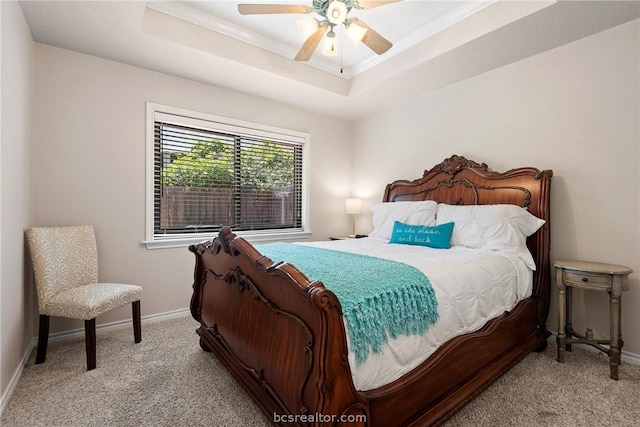 carpeted bedroom featuring a tray ceiling, ceiling fan, and ornamental molding