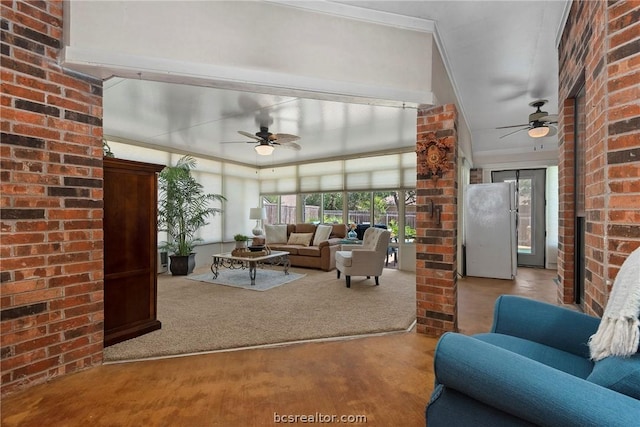 living room with carpet flooring, ceiling fan, ornamental molding, and brick wall