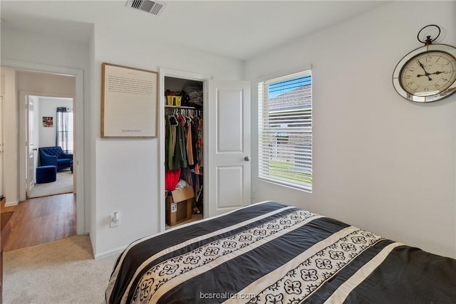 carpeted bedroom with a walk in closet and a closet