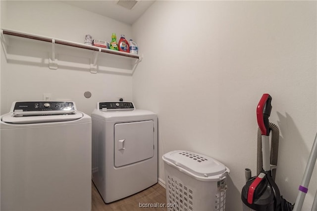 laundry room featuring hardwood / wood-style flooring and washing machine and clothes dryer