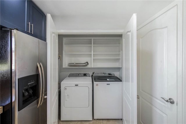 laundry room featuring light tile patterned floors, laundry area, and washing machine and clothes dryer