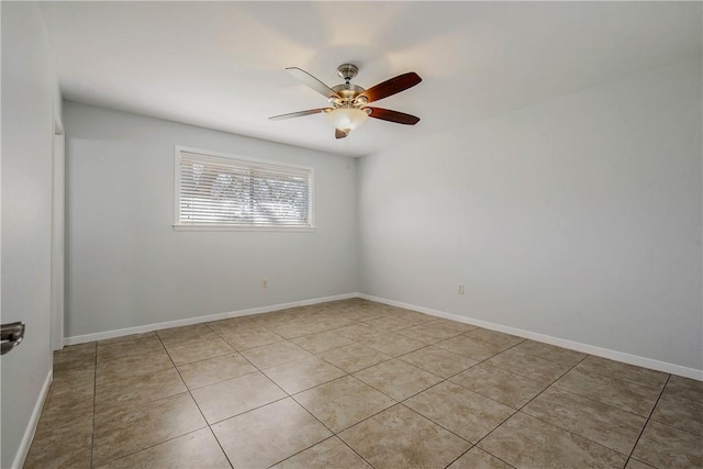 empty room featuring light tile patterned flooring, a ceiling fan, and baseboards