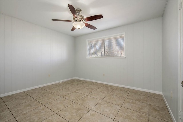 spare room featuring light tile patterned floors, baseboards, and ceiling fan