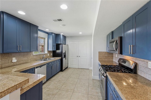 kitchen with visible vents, stainless steel appliances, blue cabinets, and decorative backsplash