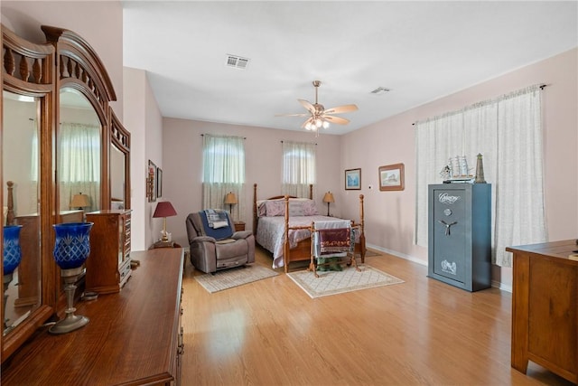 bedroom with visible vents, baseboards, light wood-style floors, and a ceiling fan