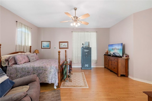 bedroom with ceiling fan, baseboards, and light wood-style floors