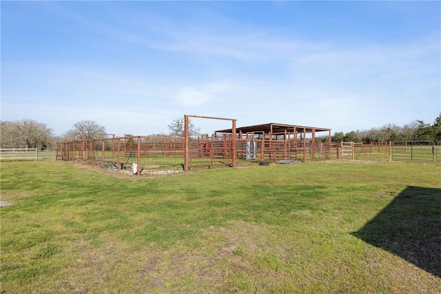 view of yard featuring an exterior structure, a rural view, and an outdoor structure