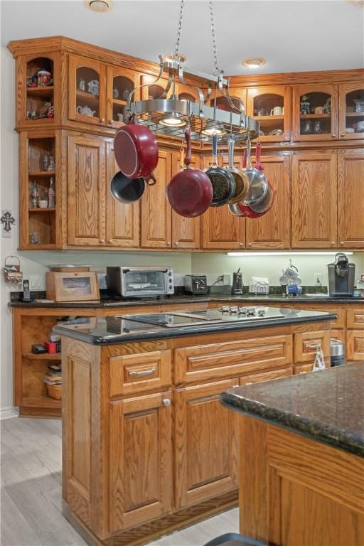 kitchen featuring open shelves, glass insert cabinets, a kitchen island, and a toaster