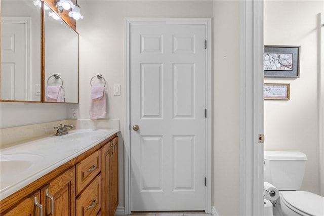 full bath featuring double vanity, toilet, and a sink