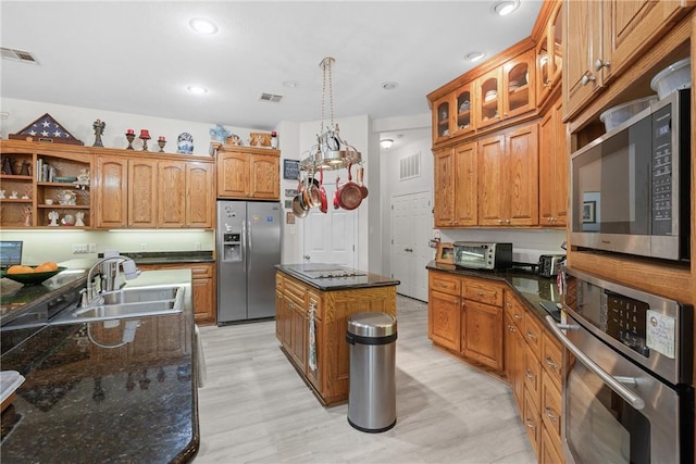 kitchen with a sink, light wood-type flooring, visible vents, and stainless steel appliances