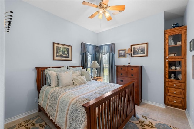 bedroom featuring light tile patterned floors, baseboards, and ceiling fan