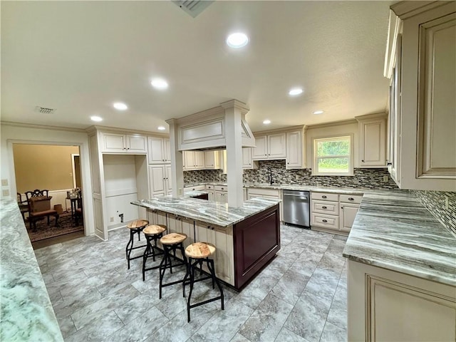 67 Fairway Dr, Hilltop Lakes, TX 77871 - kitchen with stainless steel dishwasher, backsplash, a kitchen bar, light stone counters, and a sink