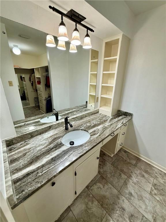 67 Fairway Dr, Hilltop Lakes, TX 77871 - bathroom featuring vanity, a spacious closet, and baseboards