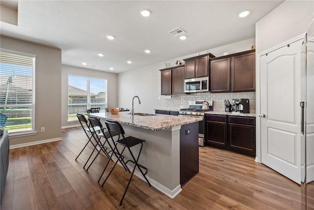 6317 Daytona Dr, College Station, TX 77845 - kitchen featuring a sink, tasteful backsplash, wood finished floors, appliances with stainless steel finishes, and visible vents