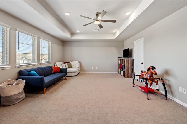 6317 Daytona Dr, College Station, TX 77845 - living area with visible vents, baseboards, ceiling fan, a raised ceiling, and light colored carpet