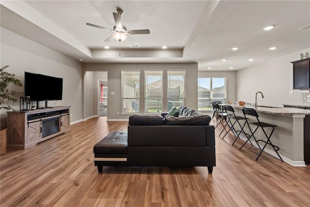 6317 Daytona Dr, College Station, TX 77845 - living room with a tray ceiling, ceiling fan, recessed lighting, and light wood-type flooring