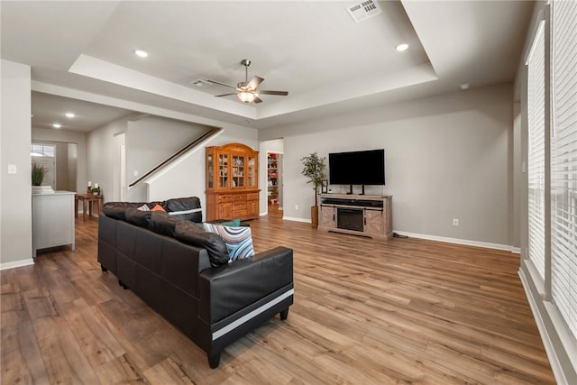 6317 Daytona Dr, College Station, TX 77845 - living room with visible vents, wood finished floors, ceiling fan, and a raised ceiling