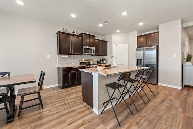 6317 Daytona Dr, College Station, TX 77845 - kitchen with dark brown cabinetry, visible vents, stainless steel appliances, and tasteful backsplash