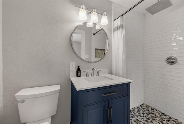 bathroom with curtained shower, vanity, and toilet