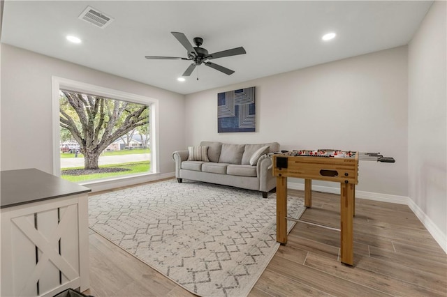 living room with light hardwood / wood-style floors and ceiling fan