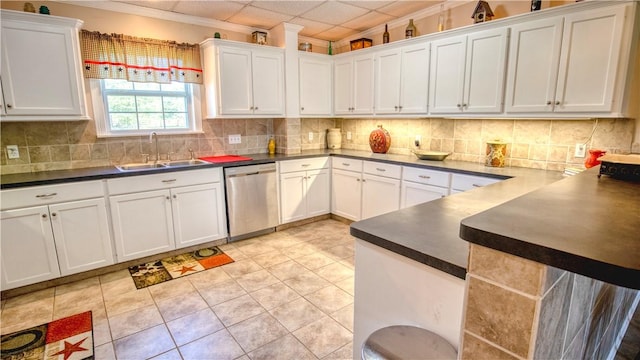 kitchen with white cabinetry, stainless steel dishwasher, sink, and backsplash