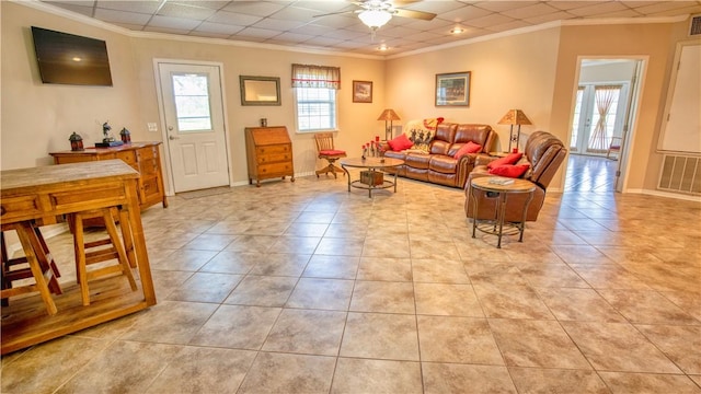 tiled living room featuring ornamental molding, a drop ceiling, and ceiling fan