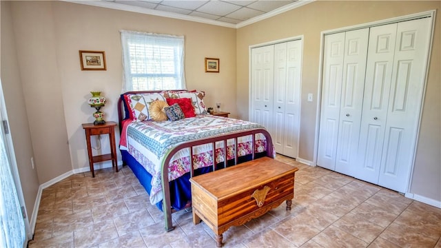 bedroom with ornamental molding and two closets