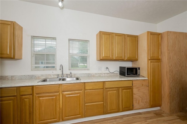 202 S Broadway St, Caldwell, TX 77836 - kitchen with stainless steel microwave, light countertops, light wood-style floors, and brown cabinetry