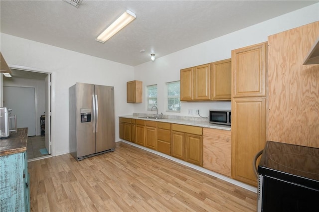202 S Broadway St, Caldwell, TX 77836 - kitchen featuring stainless steel appliances, light countertops, and light wood-style floors