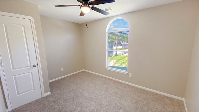 carpeted spare room featuring ceiling fan