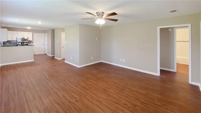 spare room with ceiling fan and dark wood-type flooring