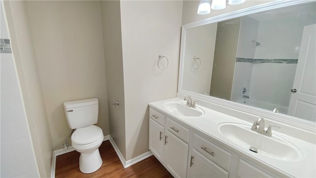 full bathroom with hardwood / wood-style floors, vanity, toilet, and shower / bathtub combination