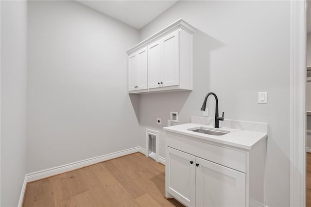 13291 Hopes Creek Rd, College Station, TX 77845 - washroom featuring hookup for an electric dryer, light wood-style floors, cabinet space, washer hookup, and baseboards