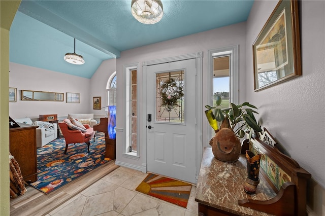 tiled entryway with lofted ceiling