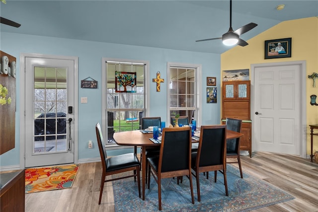 dining space featuring vaulted ceiling, a ceiling fan, and wood finished floors